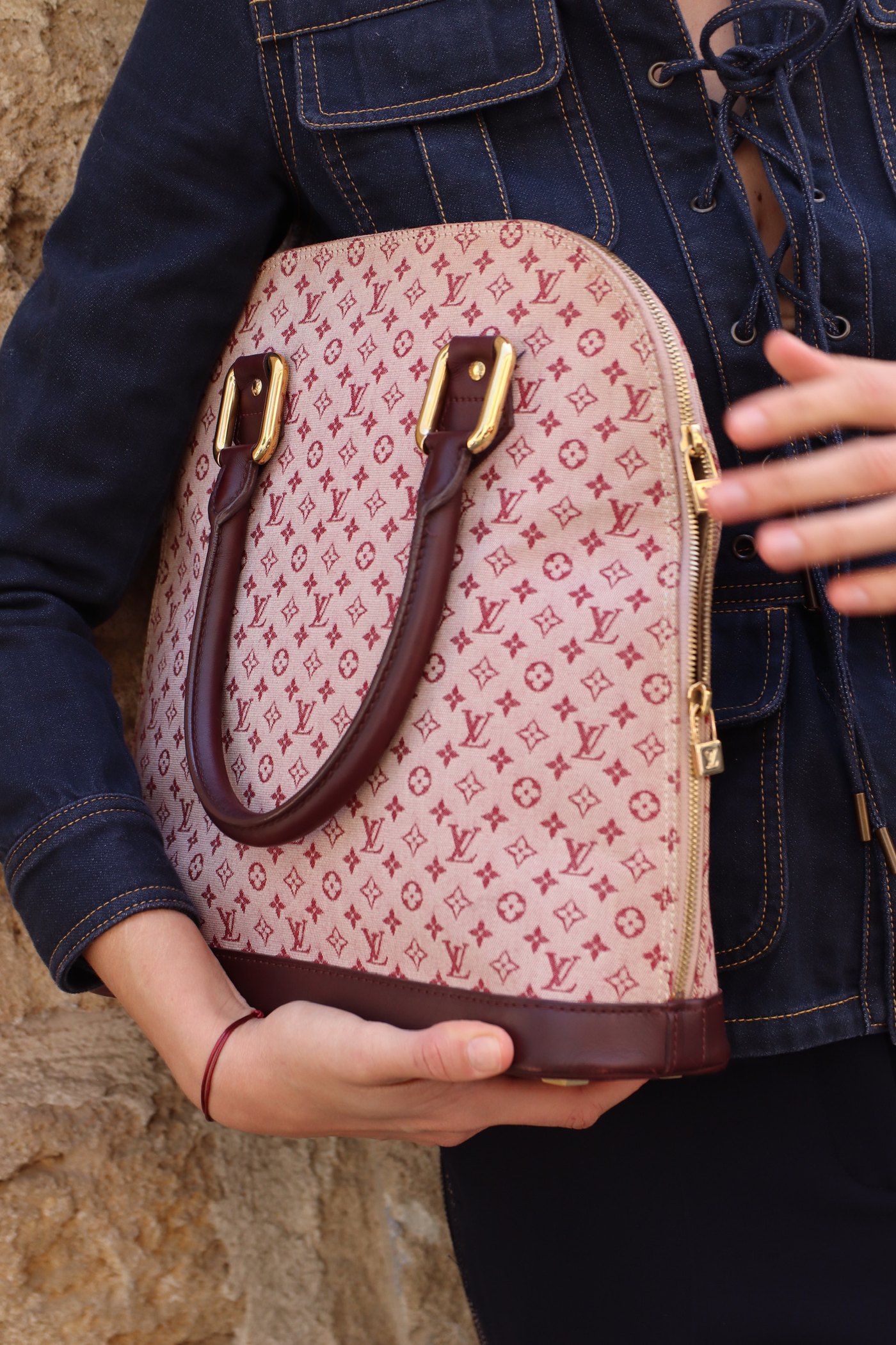 The bag held against the denim