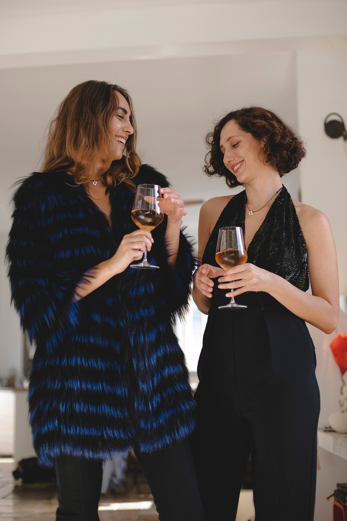 Two glasses raised indoors