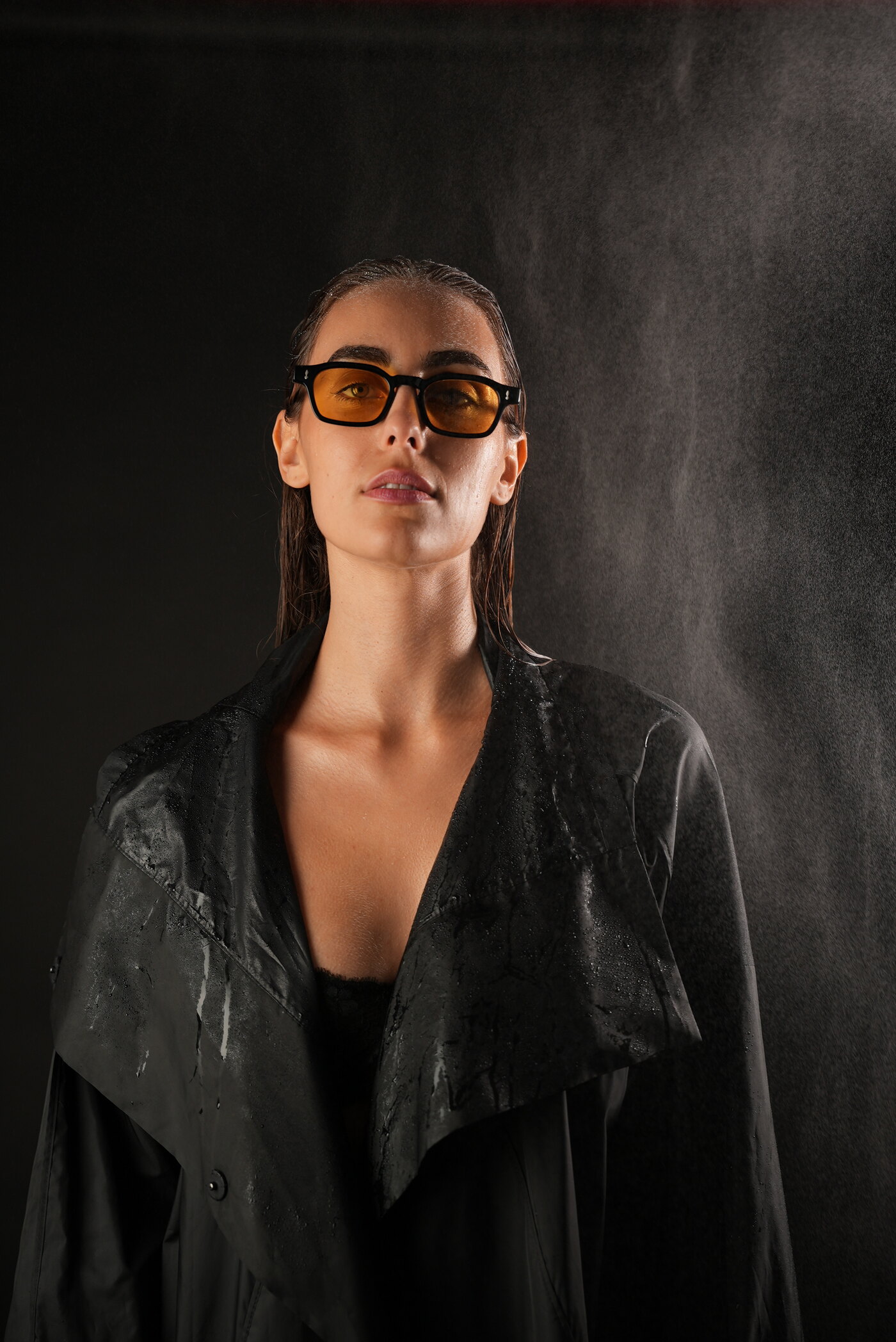 Eye Society — model in amber-tinted frames under a fine mist
